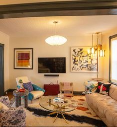 a living room filled with furniture and a flat screen tv mounted to the side of a wall