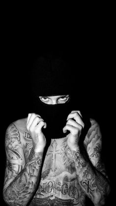 a man with tattoos covering his face in the dark