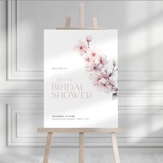 an easel with a floral bridal shower sign on it in front of a white wall