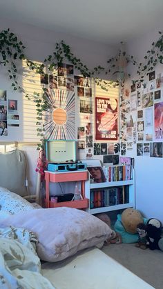 a bed room with a book shelf filled with books and pictures on the wall above it