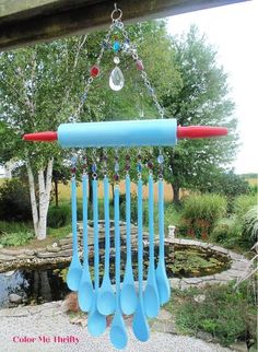 a wind chime hanging from the side of a wooden structure with spoons attached to it