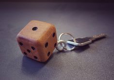 a wooden dice sitting on top of a table next to a pair of metal scissors