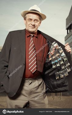 an old man in a suit and tie holding his jacket over his shoulder