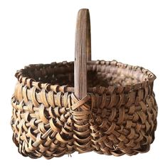 an old woven basket with a wooden stick sticking out of the top, on a white background