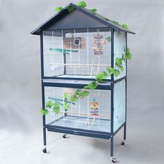 a blue bird cage with green plants growing out of it's top and sides