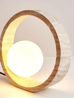 a light that is sitting on top of a white table lamp with a circular base