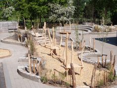 an empty park with benches and trees in the middle, surrounded by rocks and gravel