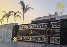 the entrance to an office building is decorated with gold and black designs, while palm trees are in the background