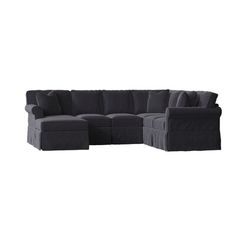 a black sectional couch with pillows on it