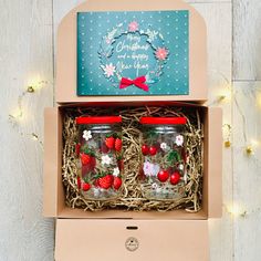 two mason jars filled with strawberries in a box