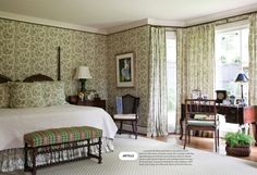 the bedroom is decorated with green and white wallpaper, including an antique style bed