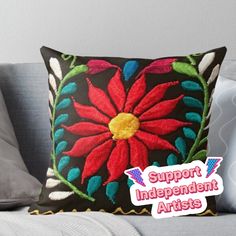 a red flower embroidered on a black pillow with the words support independent artists above it