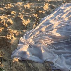 a blanket laying on top of a sandy beach