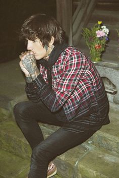 a young man sitting on steps with his hands in his mouth