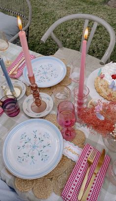 a table with plates and candles on it