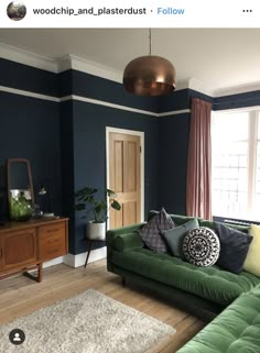 a living room with blue walls and green couches