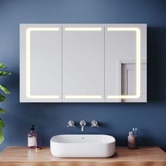 a bathroom with blue walls and a white sink in front of a mirror on the wall