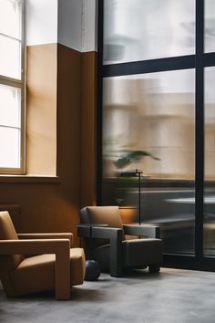 two chairs and a table in front of large windows