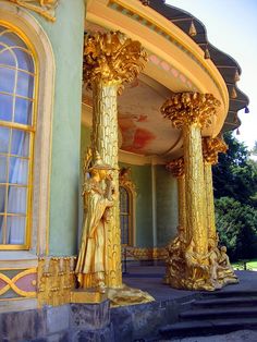 an ornate building with gold columns and statues