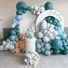 there is a teddy bear and balloon arch in the room