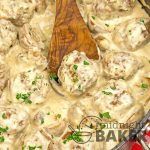 a pot filled with meatballs and gravy on top of a wooden spoon