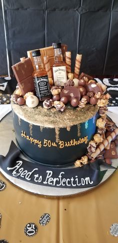 a birthday cake decorated with chocolates, candies and other items on a table