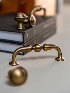 two books are sitting on a table next to a brass door handle and knobs