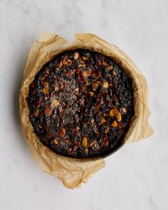 a pie sitting on top of a table covered in brown paper wrappers and nuts