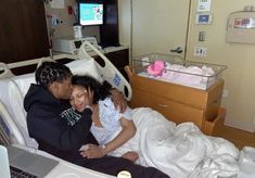 a man and woman laying in a hospital bed