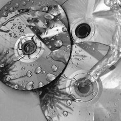 two discs sitting on top of a table covered in raindrops and water droplets