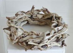 a wreath made out of driftwood sitting on top of a white box