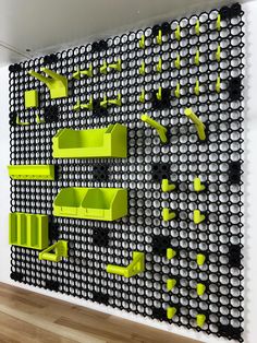 the wall is made out of black and white circles with neon green shelves on each side