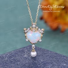 "Natural Opal Necklace Heart Opal Pendant Two Tones Vintage Yellow Gold Pearl Pendant Art Deco Diamond Cluster October Birthstone Gift Women Lab Opal Center listing: https://www.etsy.com/listing/1179605889 Item As Shown in Solid 14K Yellow Gold Also available in yellow gold, white gold, rose gold / Solid 14K & 18K △ center stone: Natural Fire Opal, Heart Shaped -Measures: 8mm △ side stones: 3.5mm Natural Akoya Pearl △ side stones: 0.065ct Colorless Moissanite / Natural Diamond (H, SI1) (select t Heart Shaped Jeweled Jewelry For Gift, Heart-shaped Jeweled Jewelry For Gift, Heart-shaped Jeweled Jewelry Gift, Opal Necklaces, Elegant Handmade Round Heart Necklace, Elegant Handmade Heart Necklace, Heart-shaped Wedding Jewelry, Heart Shaped Wedding Jewelry, Heart-shaped Wedding Jewelry With Jewels