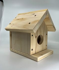 a wooden bird house sitting on top of a white table