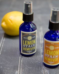 two bottles of lemon stain remover next to a lemon