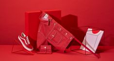 an assortment of red and white items sitting on top of a red surface, including a pair of sneakers