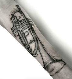 a man's arm with a black and white tattoo of a trumpet on it