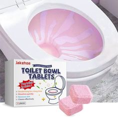 a toilet bowl with pink and white paint on the lid next to two sponges