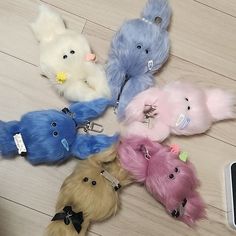 several stuffed animals are on the floor next to a cell phone