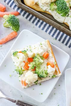 a slice of broccoli and cauliflower pizza on a white plate next to carrots