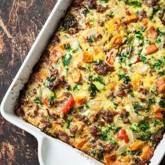 a casserole dish with meat, cheese and veggies in it on a table