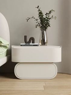 a white table sitting on top of a hard wood floor next to a bed with green sheets