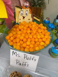 there is a plate full of oranges and muffins for sale at the table