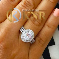 a woman's hand holding an engagement ring with diamonds on the top and bottom