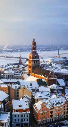 an aerial view of a city with snow on the ground and buildings in the foreground