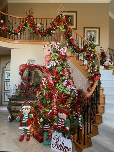 a christmas tree is decorated with candy canes and bows, while other decorations are on the stairs