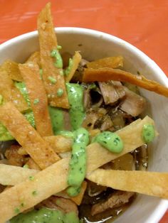 a white bowl filled with lots of food on top of a table