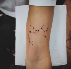 a person with a star tattoo on their arm that has the shape of a zodiac sign