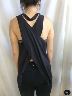 the back of a woman's black top with an asymmetrical design