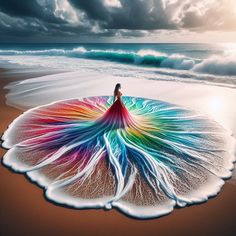 a woman standing on the beach in front of an ocean wave with her colorful dress